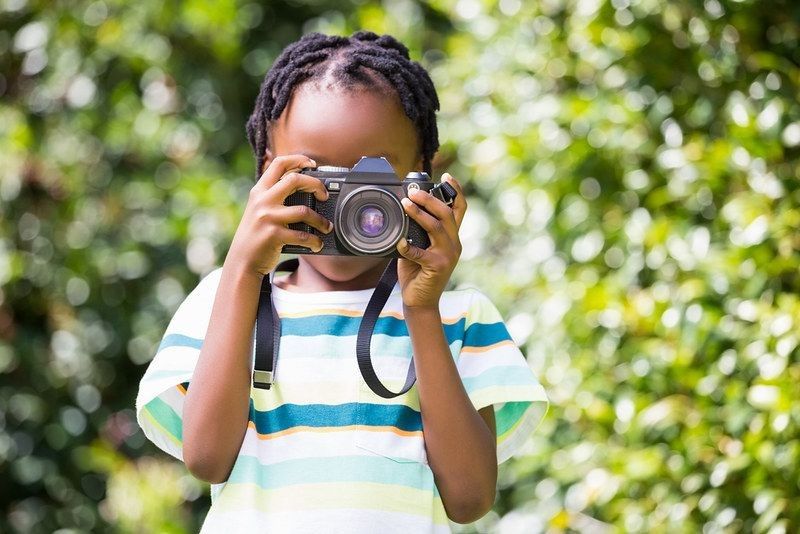 A child taking pictures in park