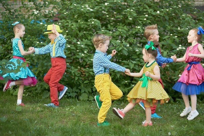 Three kids' couples dancing on lawn.