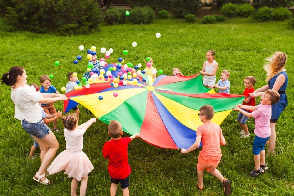 Playing in fresh air with parachute and balls
