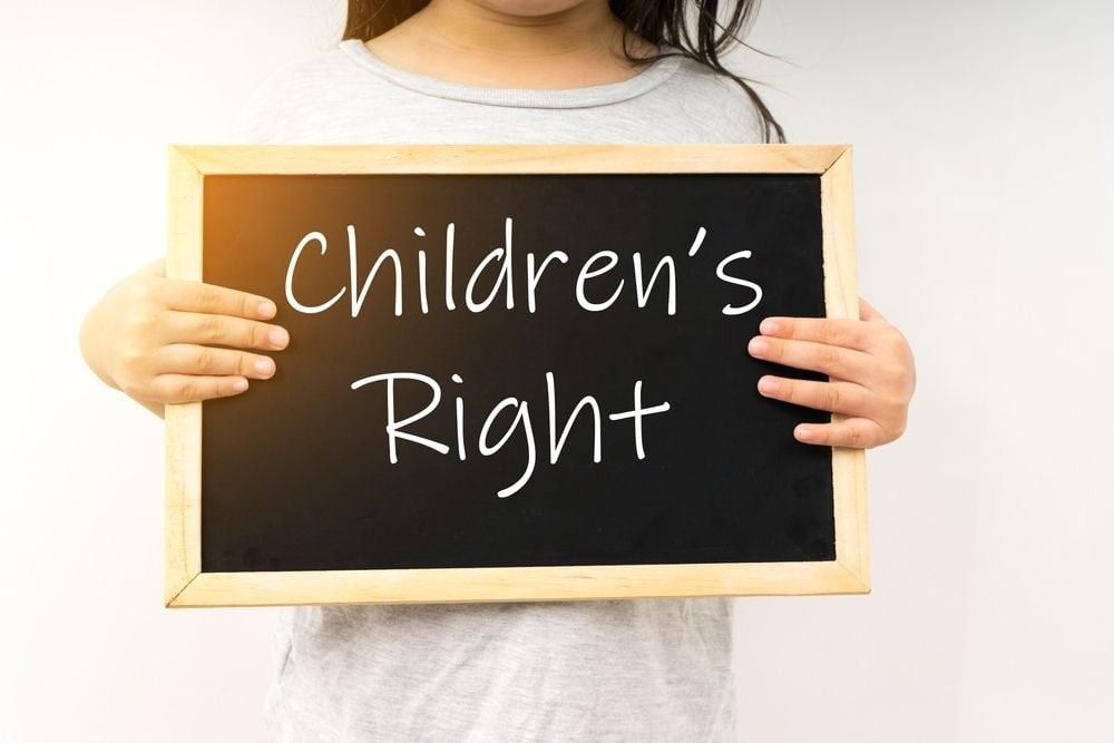 Children's right concept with a young girl hold the chalkboard.