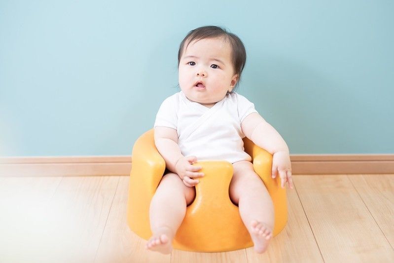 Ethnic Asian Baby sitting in yellow chair