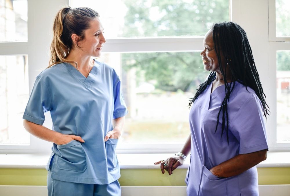 Nurses having a conversation in the hospital hallway.