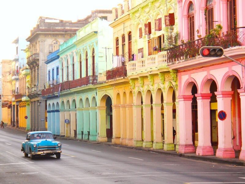Colorful buildings and car on road in Cuba.