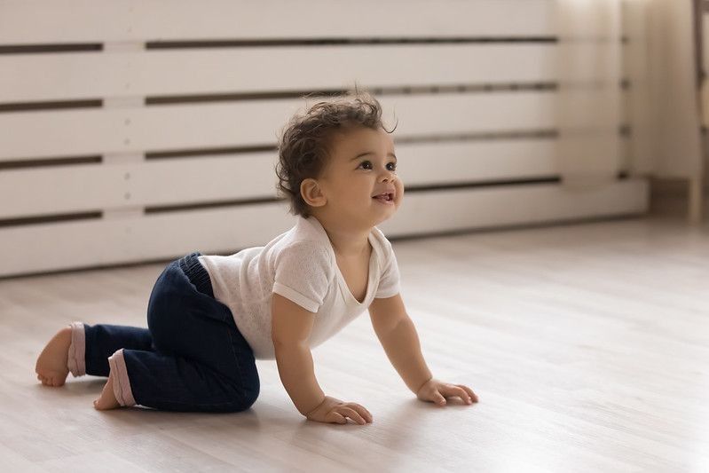 Cute little ethnic baby crawling in indoor.