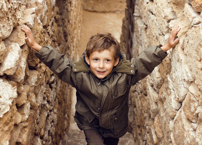 Little cute boy among ancient ruins