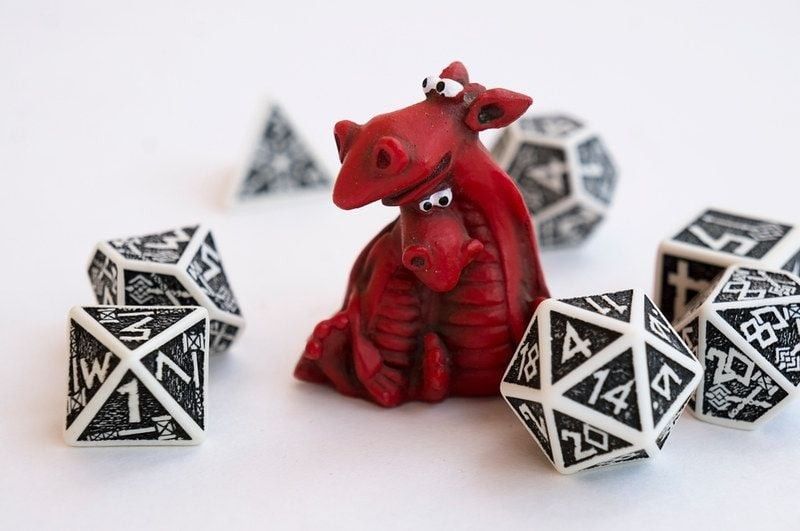 Miniature of two cute red dragons and black and white dices