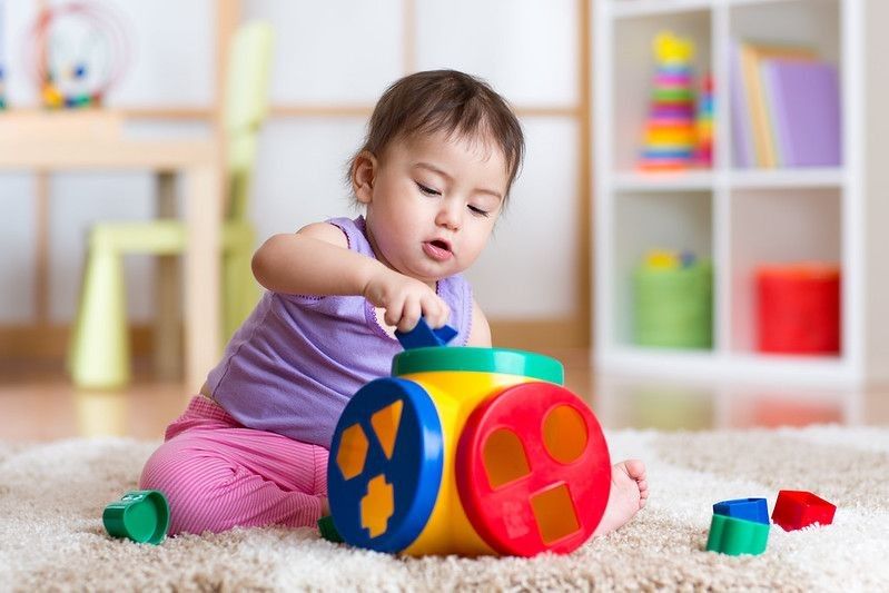Girl plays with educational toy indoor.