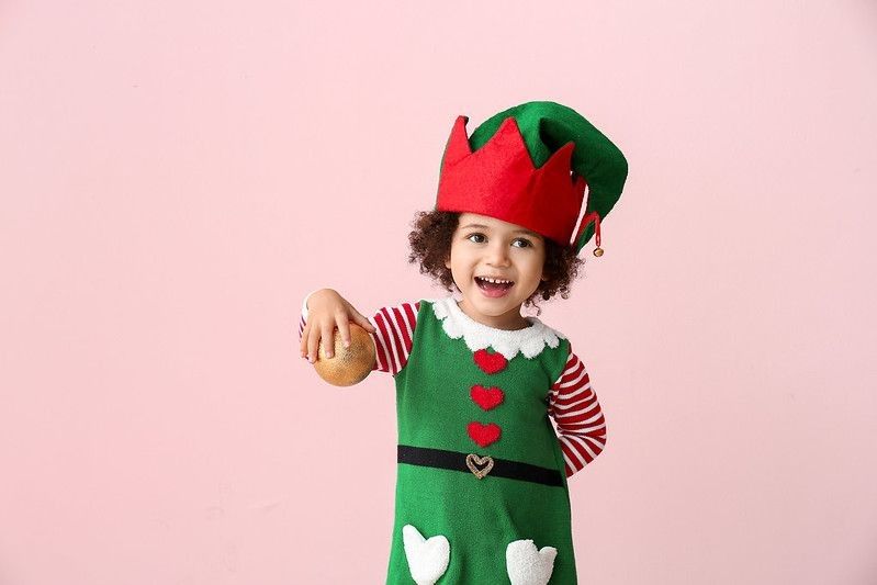 Little girl wearing green elf costume