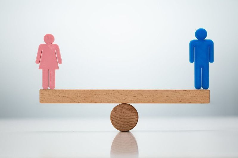 Gender Equality Concept. Male And Female Balancing On Seesaw