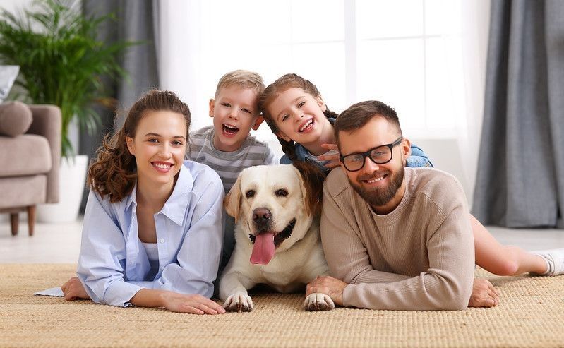 Family lying together with dog.
