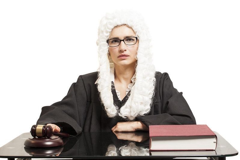 Female judge wearing a wig and Black mantle