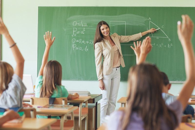 A female teacher is teaching maths to kids
