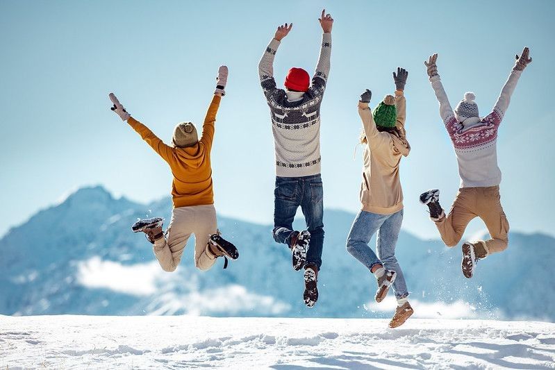 Friends jumping happily on a snowy mountain