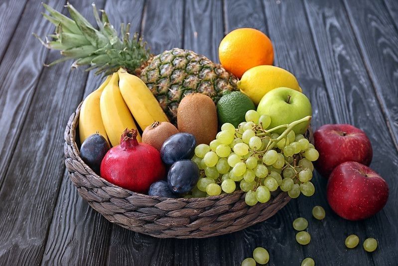 A basket with fresh fruits on wooden table
