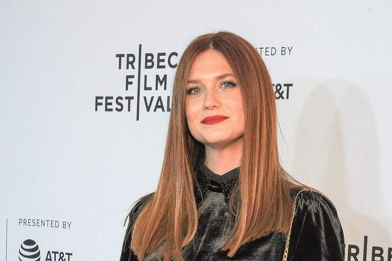 Actress Bonnie Wright, who played Ginny Weasley in the Harry Potter movies, posing for the camera at an event.