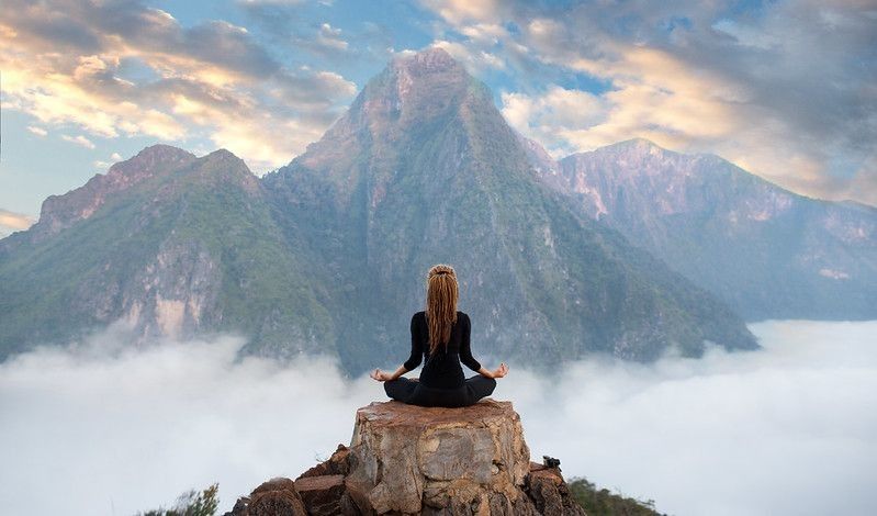 Woman meditating on mountain 