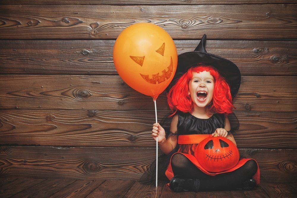 Laughing funny child girl in a witch costume in halloween.