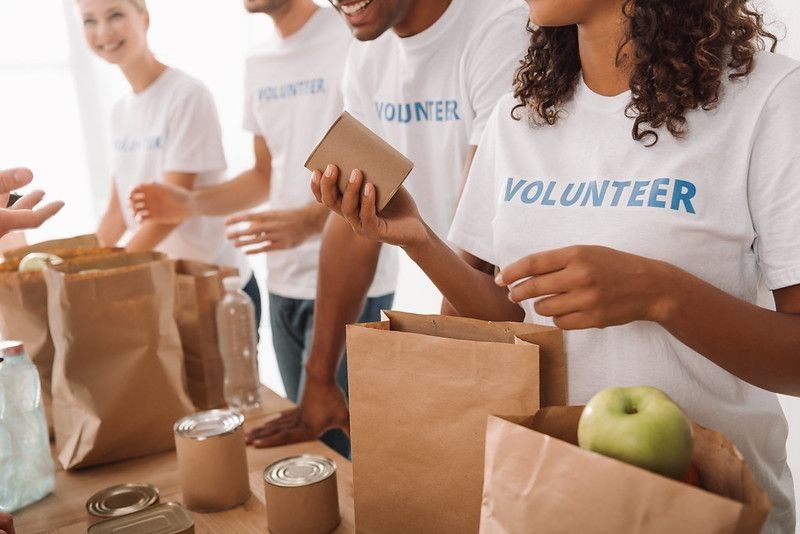 cropped shot of young volunteers group packing food