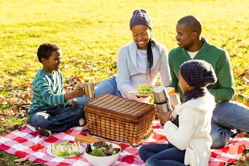 Young smiling family doing a picnic on an autumn day