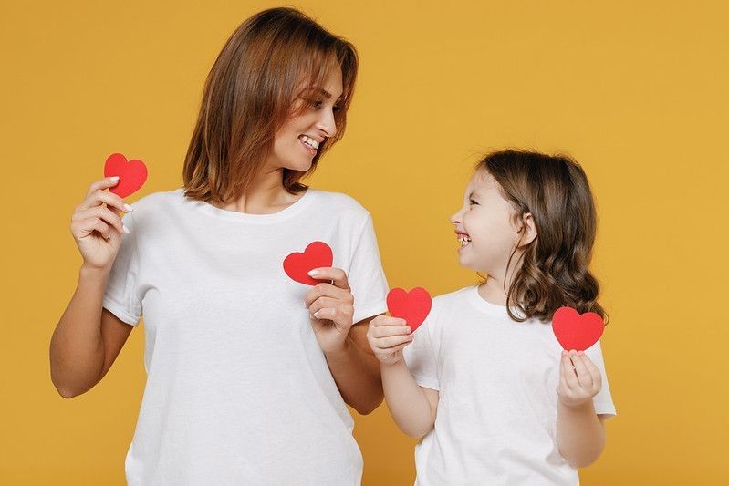 Happy woman in basic white t-shirt haveing fun and with child
