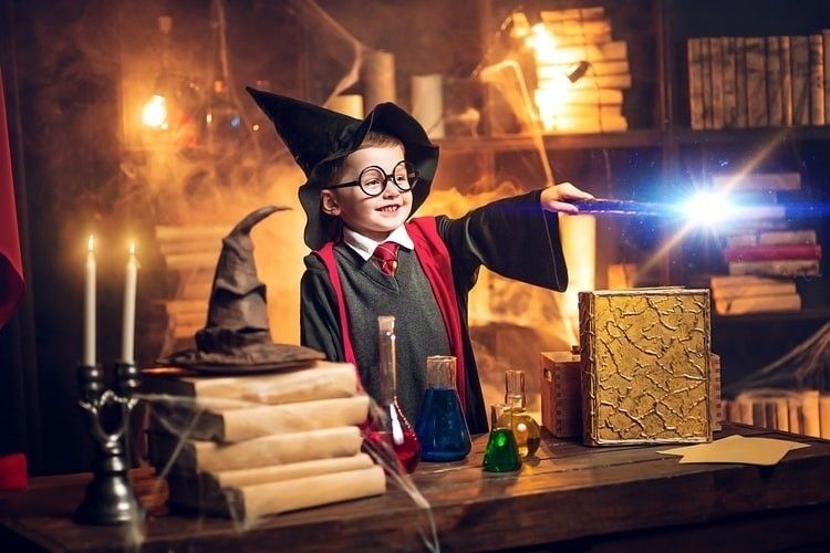 A little boy dressed as wizard in a lab.