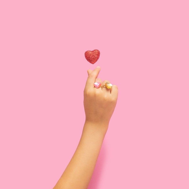 Girl's hand making a popular Kpop heart gesture