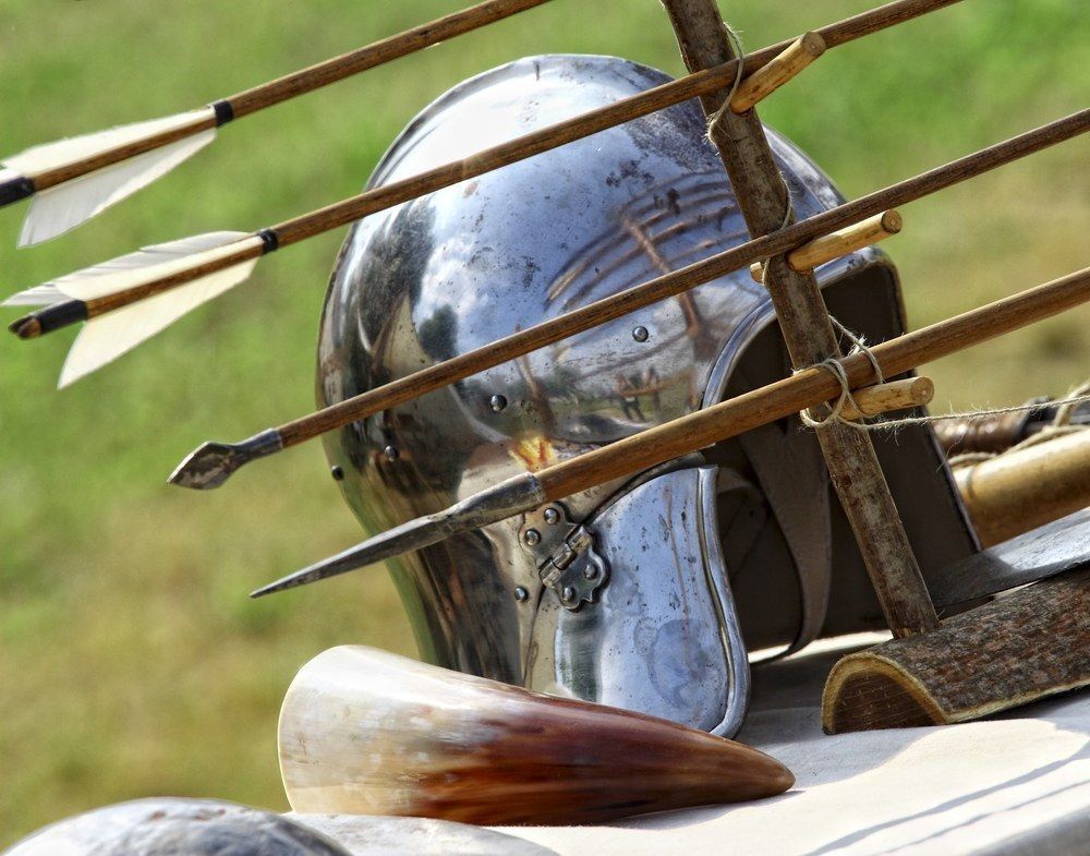 Close up of ancient metal helmet and arrows background