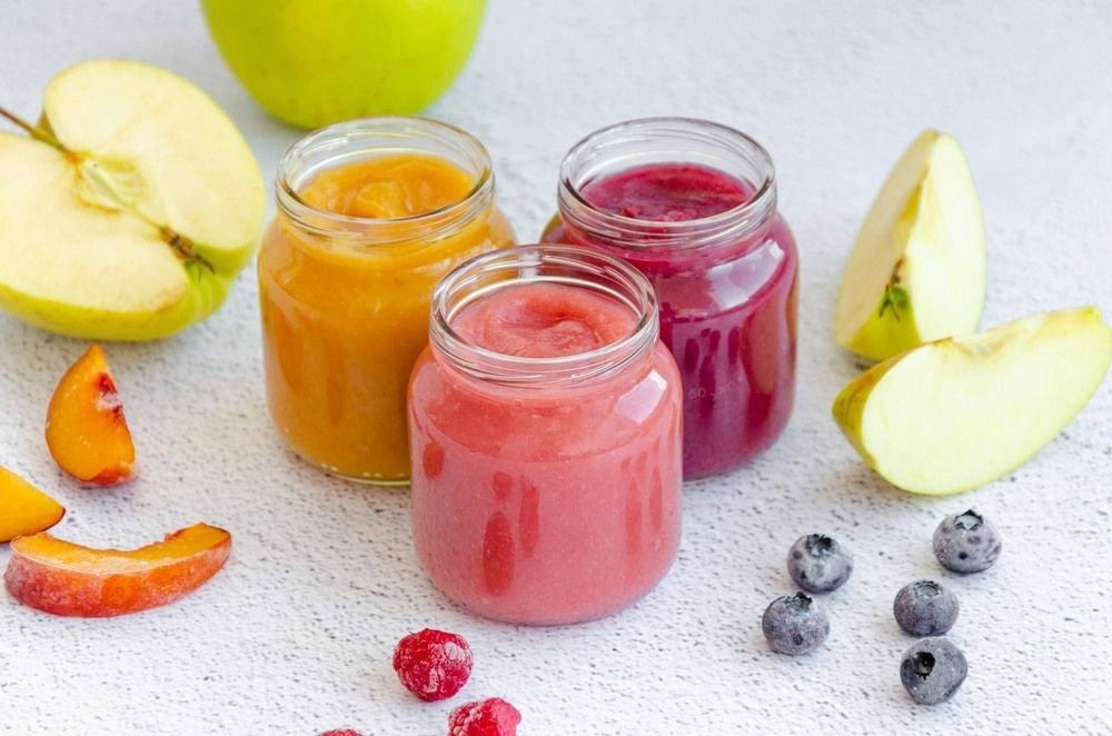 Smoothies in three glass jars on a light background