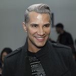 Jay Manuel at The Blonds Fashion show, part of New York Fashion Week at Milk studio, smiling in a black coat.