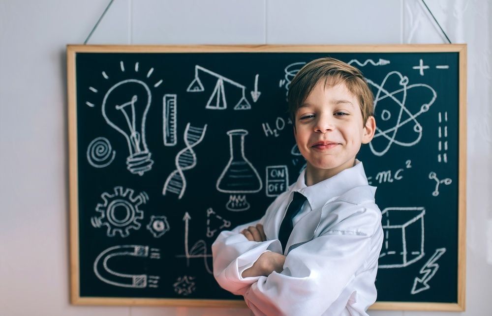 Smiling kid in front of blackboard