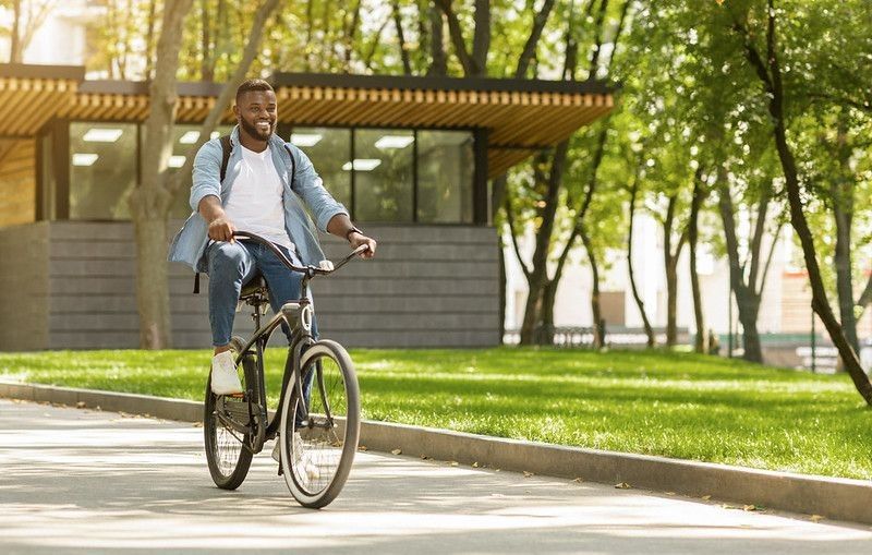 Happy young man riding on his bicycle to work