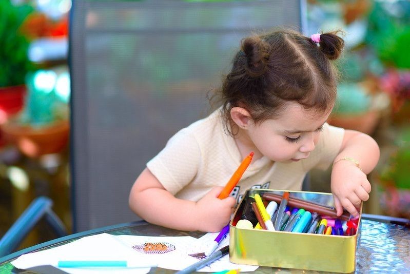 Little girl painting in kindergarden