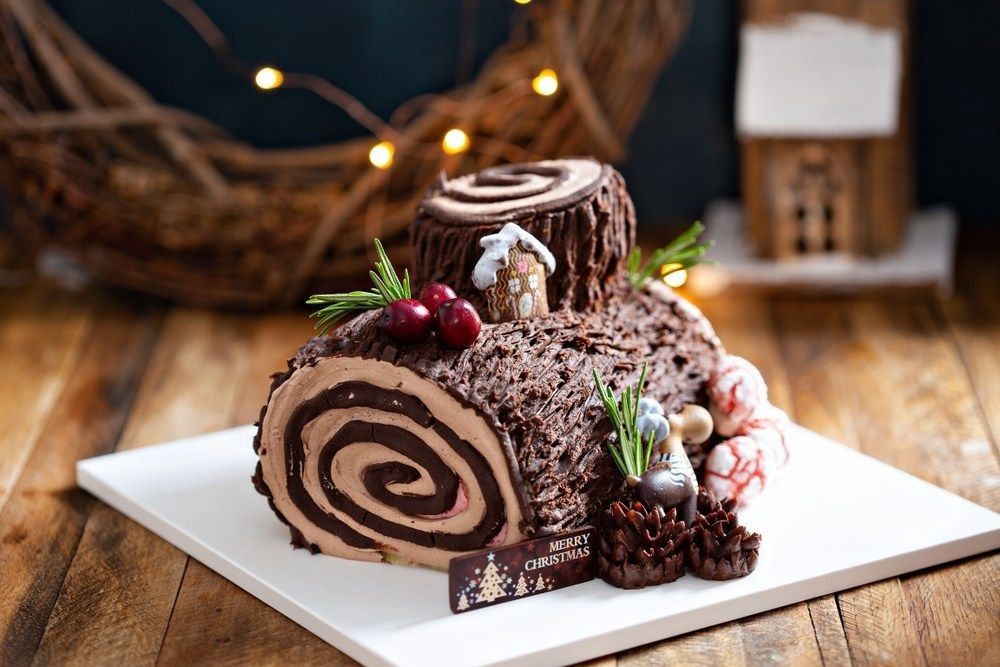 Yule log roll cake for Christmas decorated with chocolate ganache.
