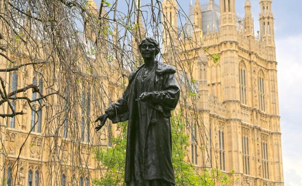 Statue of Emmeline Pankhurst, the main british suffragette, in the Victoria Tower Gardens, created by Arthur George Walker, with the Houses of Parliament.