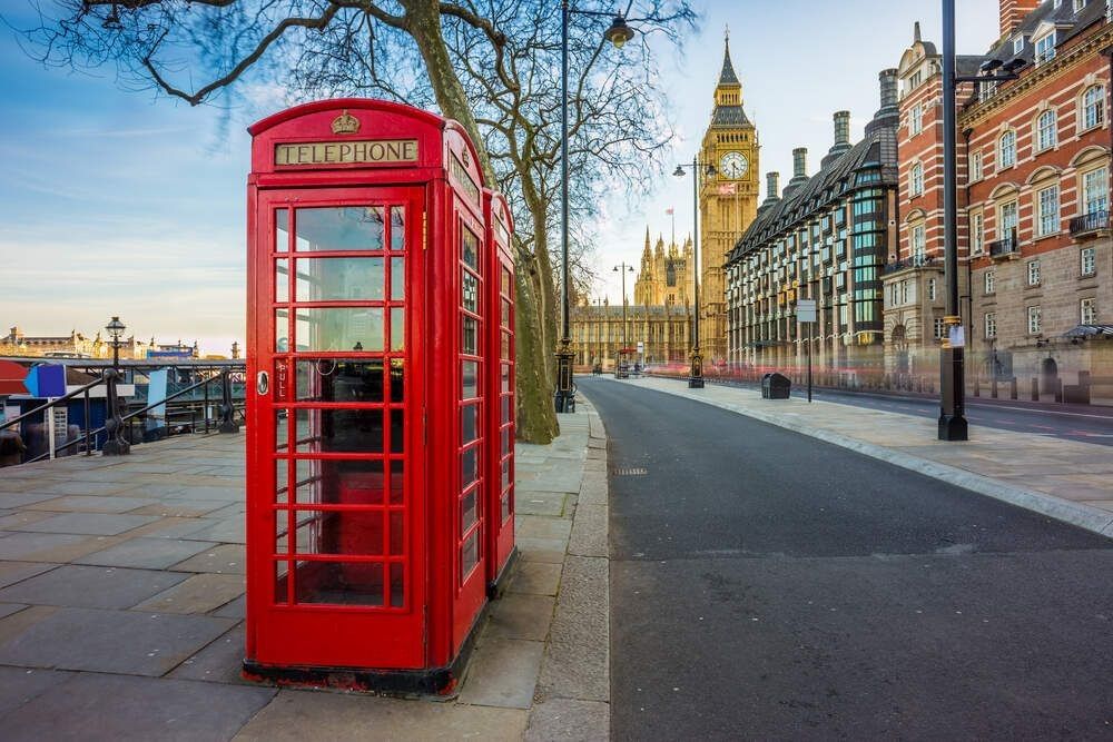 Traditional Old British red telephone box at Victoria Embankment with Big Ben in background