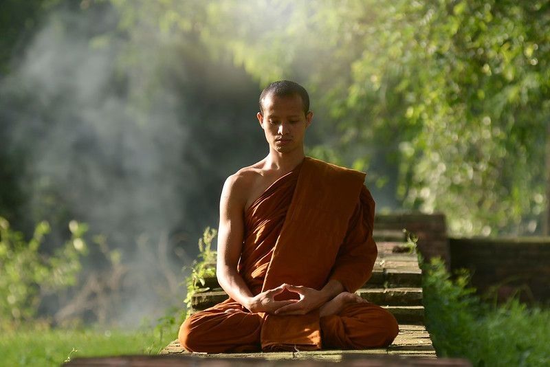 Monk praying silently in forest