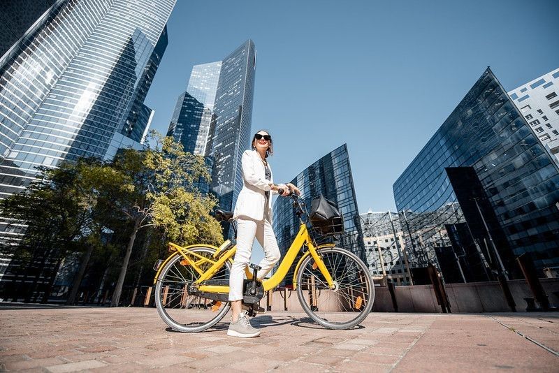 Young business woman using a bicyle to reach her office