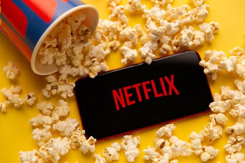 Popcorn spilling over the phone displaying Netflix icon