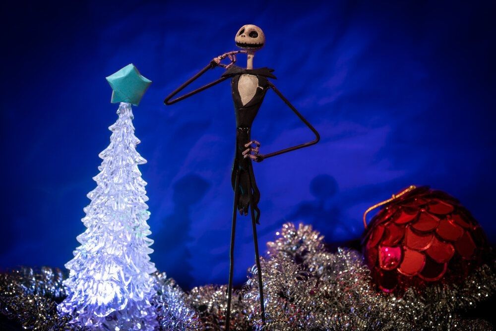 Charming Jack Skellington from Night Before Christmas surrounded by festive adornments in a blue background