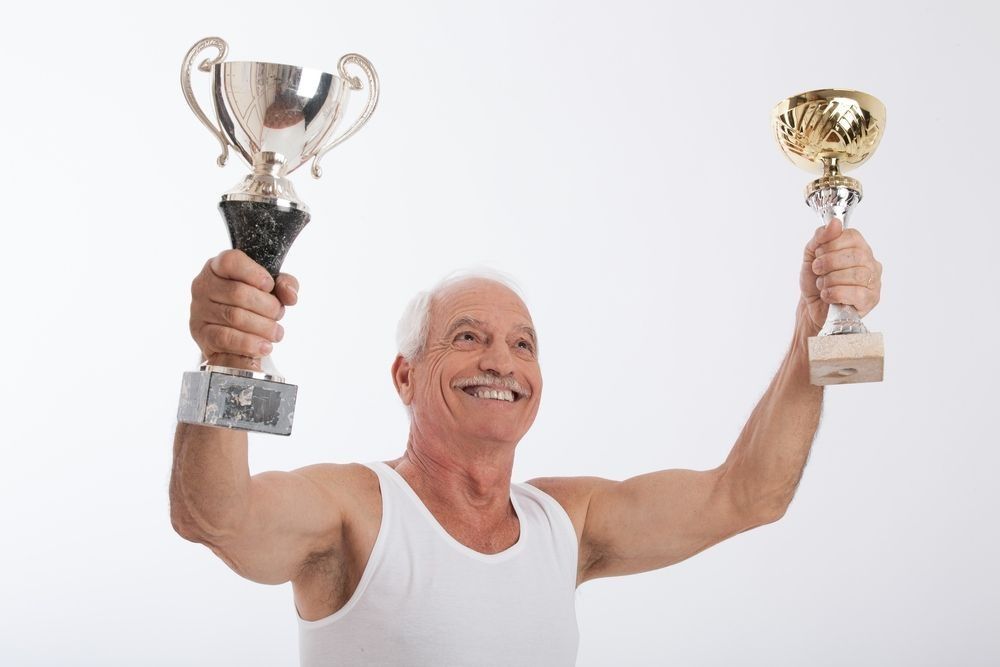 Old man holding winning cup