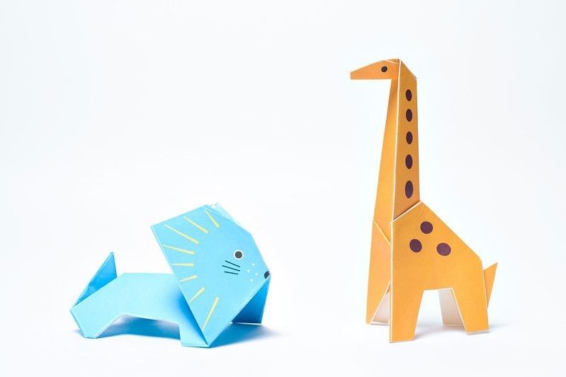 Origami giraffe and blue lion on white background