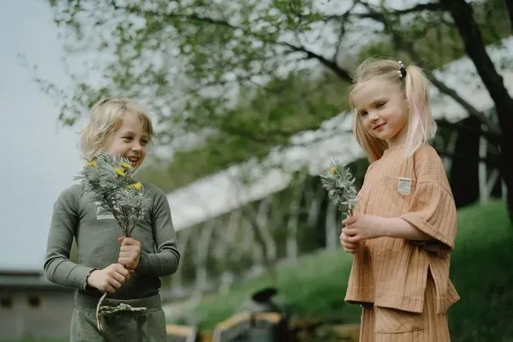 Kids holding flower plants in their hands