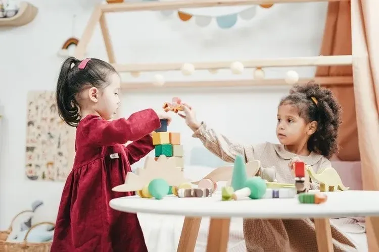 Two girls playing with wooden toys