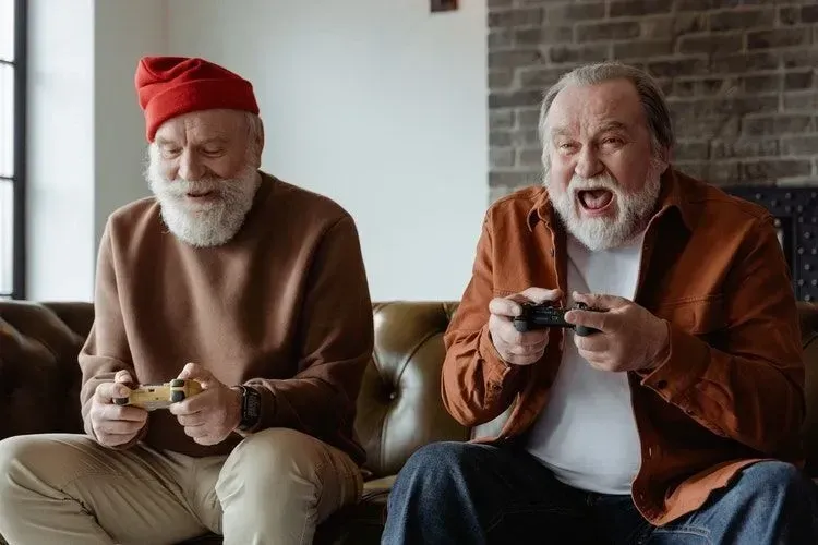 Two elder men happily playing video games