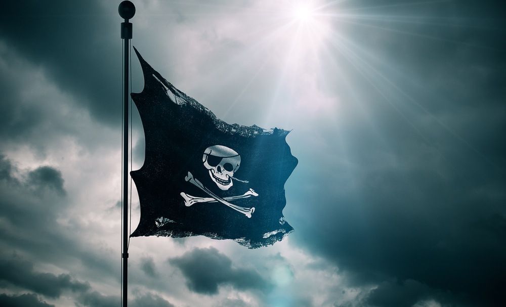 Ripped tear grunge old fabric texture of the pirate skull flag waving in wind
