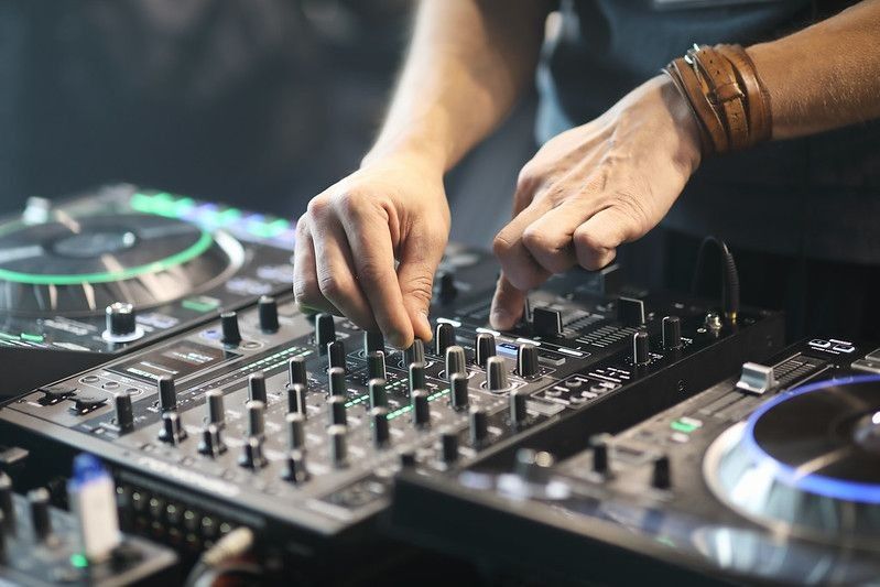 DJ using sound controller to mix music.