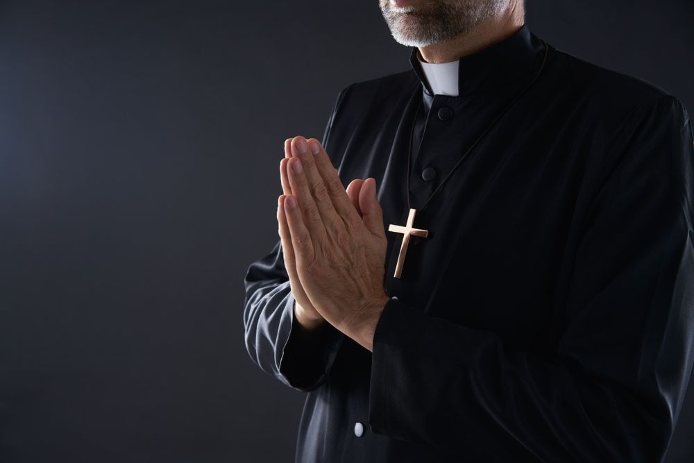 Praying hands priest portrait of male pastor.