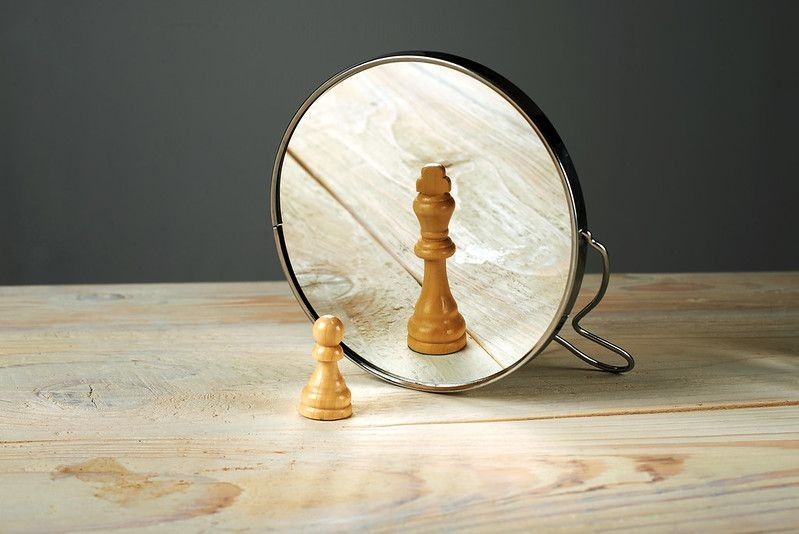 Round mirror placed on wooden table