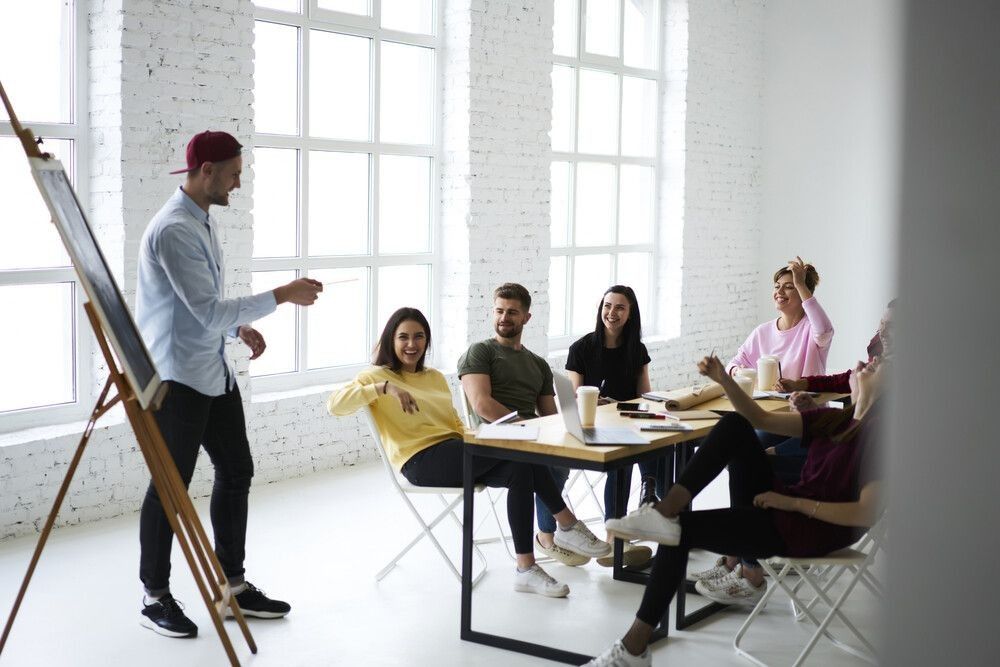 Skilled marketing expert presenting creative ideas for advertising campaign to group of colleagues during meeting in office