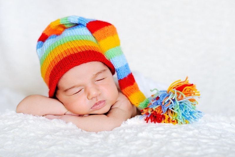 Close-up of sleeping newborn posed on white blanked.
